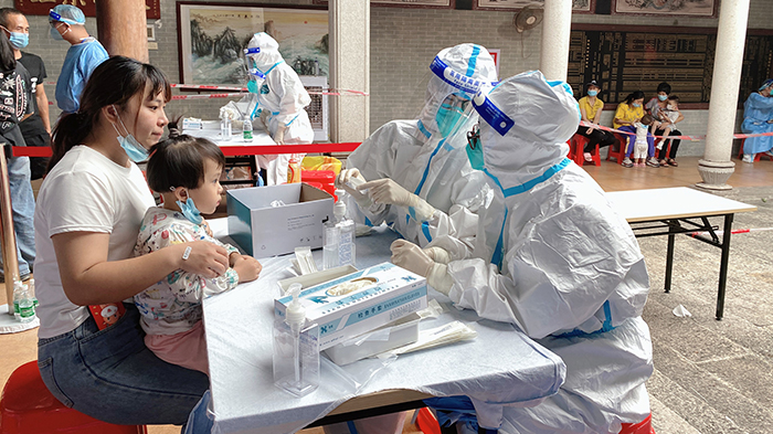 醫(yī)護(hù)人員隔著防護(hù)服為戰(zhàn)疫“加油”